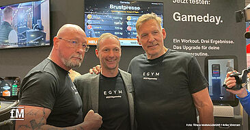 Markenbotschafter Ralf Moeller zu Besuch am EGYM Stand mit CCO Christoph Bischoff (Mitte) und Uwe Hück, ehemaliger Porsche Betriebsratchef