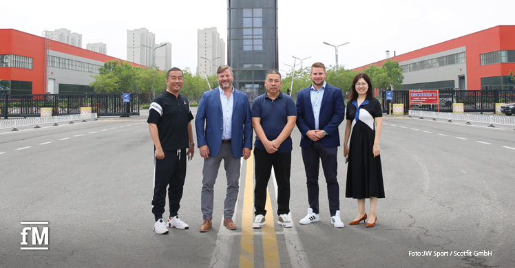 Jimmy und James Andrew mit der Unternehmensleitung von JW Sport vor der Produktionsstätte in Dezhou