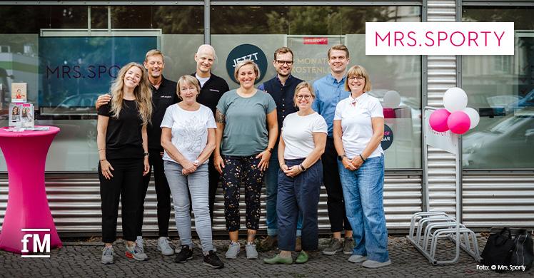 Jan Schmelzle, Geschäftsführer des Deutschen Franchiseverbands, und Niclas Bönström, Mrs.Sporty-Gründer und Geschäftsführer, und die Teams vor dem Mrs.Sporty-Club Berlin Westend.