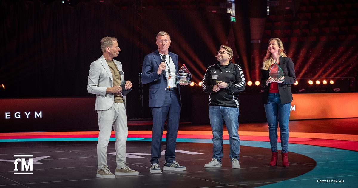 Ehre für besondere Verdienste: Christin und Mario Görlach (Zweiter von links) erhalten den ersten EGYM Achievement Award für ihren Beitrag zum Unternehmenserfolg, hier mit Moderator Markus Othmer (links) und EGYM CEO Philipp Roesch-Schlanderer