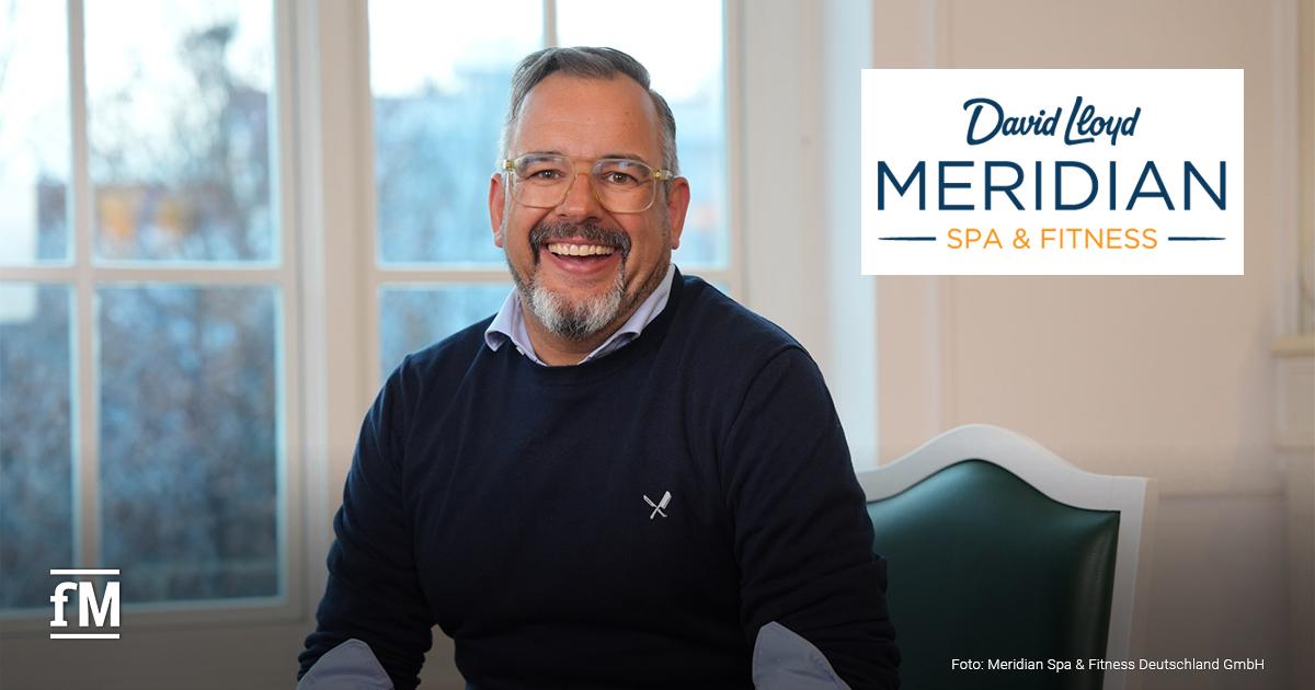 Ein lächelnder Mann mit Brille und grauem Bart sitzt in einem hellen Raum vor einem Fenster. Es handelt sich um Marcel Kloos, den neuen Country Director von David Lloyd Clubs Deutschland.