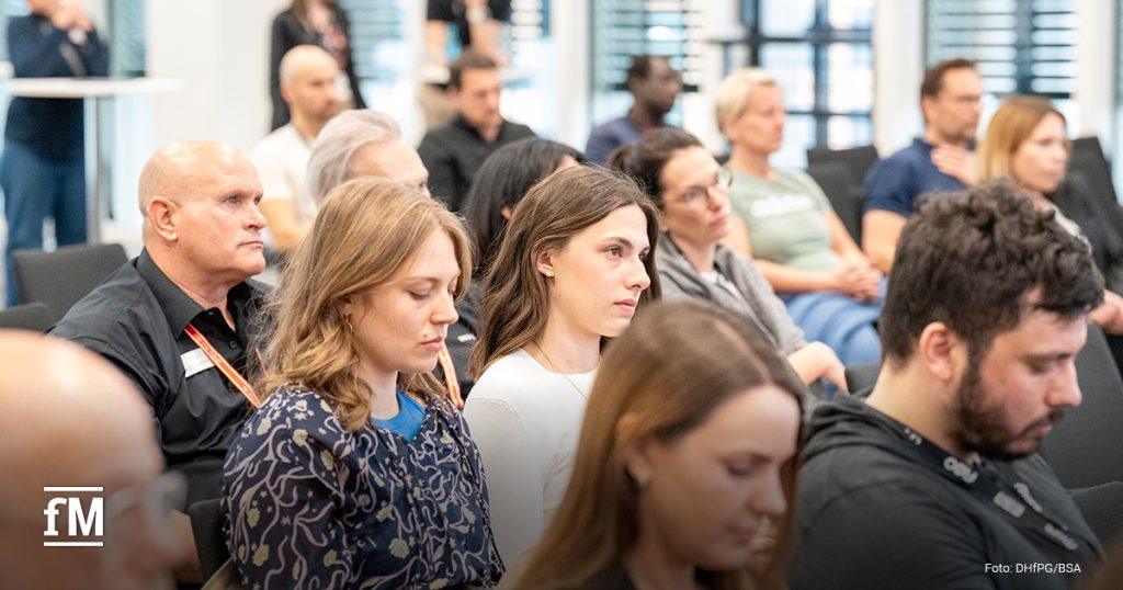Zuschauerinnen und Zuschauer sitzen aufmerksam im Vortragssaal des 'FIBO Congress'. Der Fokus liegt auf den vorderen Reihen. Die Menschen wirken konzentriert und interessiert an der Präsentation.