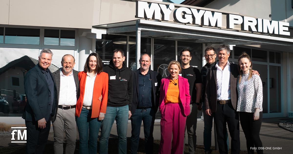 Zehn Vertreterinnen und Vertreter der Markenallianz Österreich (EGYM, seca, MATRIX, DSB-ONE, Sensopro und Wellpass) stehen lächelnd vor dem Fitnessstudio. Sie tragen legere bis elegante Kleidung. Im Hintergrund ist die gläserne Fassade des Studios zu sehen.