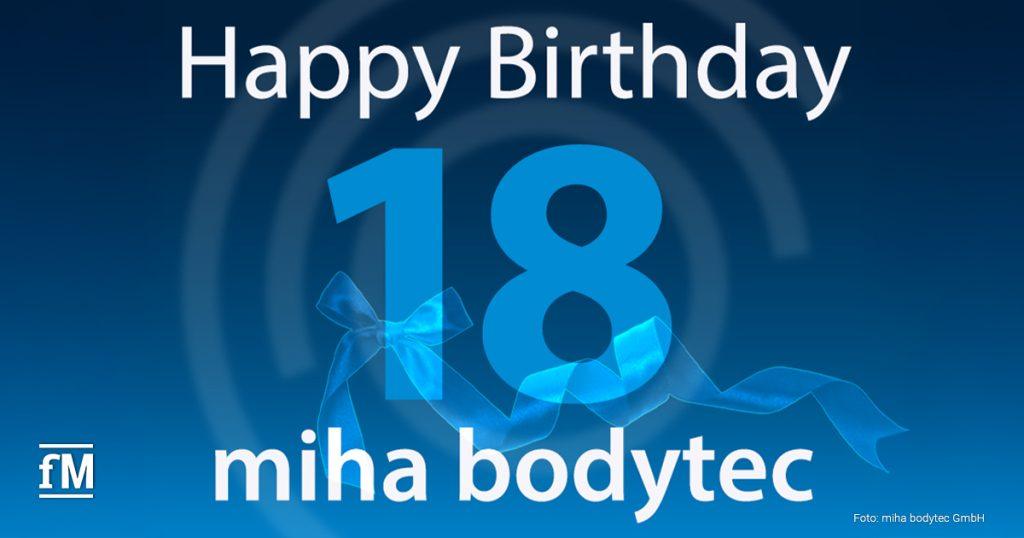 Auf einem blauen Hintergrund steht in weißer Schrift „Happy Birthday“. Darunter eine große blaue „18“, um die eine blaue Schleife gebunden ist. Am unteren Bildrand steht in Weiß „miha bodytec“