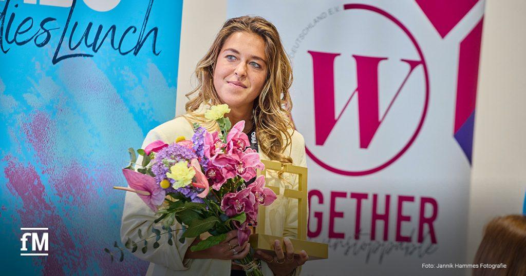 Frances Weber hält einen Blumenstrauß und den RX Female Award beim FIBO Ladies Lunch 2025 in den Händen und freut sich über ihre Auszeichnung in der Kategorie 'Youngster'.