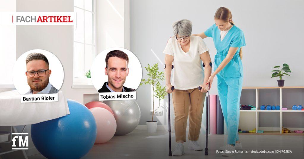 Eine ältere Frau mit grauen Haaren wird in einem hellen Raum von einer Physiotherapeutin in blauer Kleidung beim Gehen mit Gehhilfen unterstützt. Im Hintergrund stehen Gymnastikbälle und Trainingsgeräte.