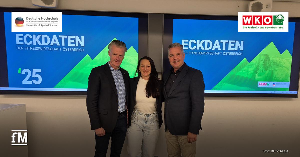 Auf dem Bild stehen drei Personen vor einer Präsentationswand (von links): Ralf Capelan mit blauem Hemd, dunkler Hose und schwarzem Sakko, Prof. Dr. Sarah Kobel in schwarzem Blazer mit beigefarbenem Pullover, Christian Hörl in schwarzem Anzug mit dunkelgrauem Hemd. Alle drei lächeln in Richtung Kamera.
