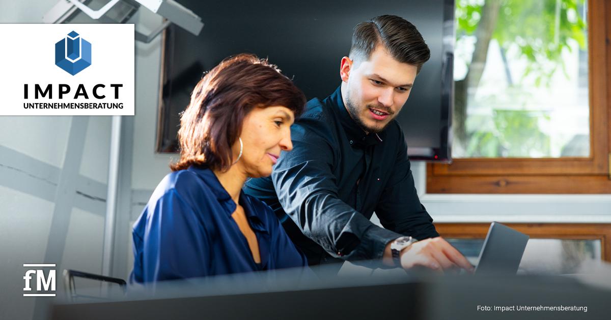Eine Frau und ein Mann im Gespräch in einem modernen Büro.