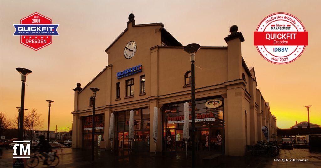 Außenansicht des QUICKFIT Dresden bei Sonnenuntergang. Oben ein Uhrturm, unten Eingänge zu Bäckerei und Supermarkt. Zwei Logos zeigen: 'DSSV-Studio des Monats' im Juni 2025 und in Blau und Rot den Unternehmensschriftzug.