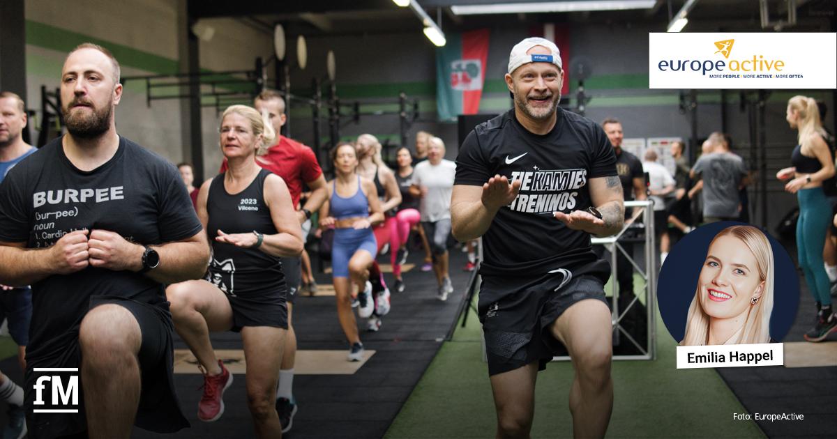 Gruppe von Menschen bei einem intensiven Gruppentraining in einer CrossFit-Halle; vorn zwei Männer und eine Frau beim Ausführen von Fitnessübungen; oben rechts EuropeActive-Logo, unten rechts ein Porträtfoto mit dem Namen Emilia Happel, unten links fM-Logo.