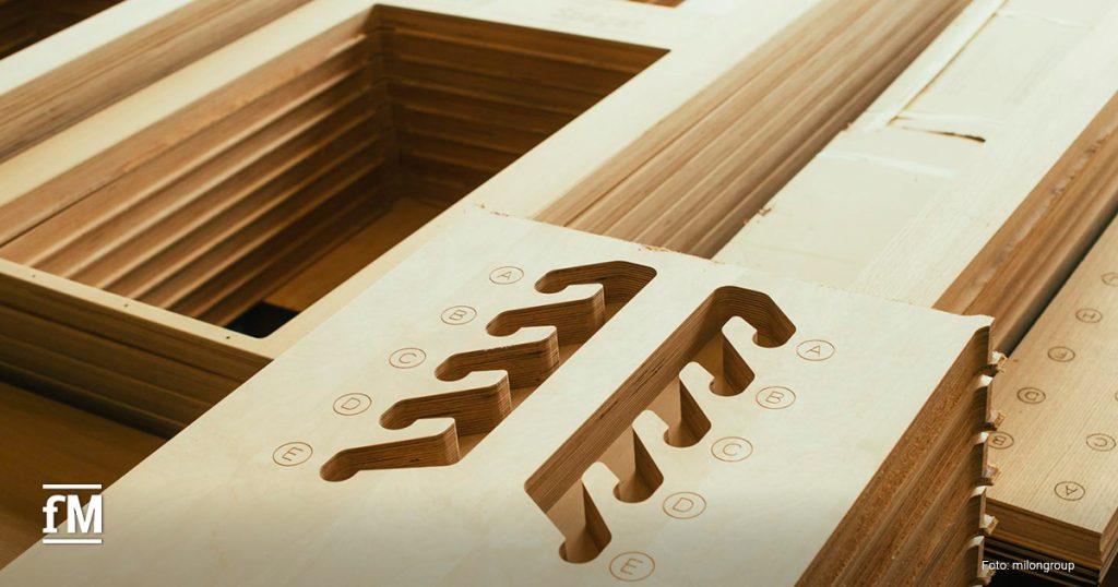 Detailaufnahme von gefrästen Holzplatten mit eingravierten Buchstaben und Schlitzen, Bestandteil der five Geräte.