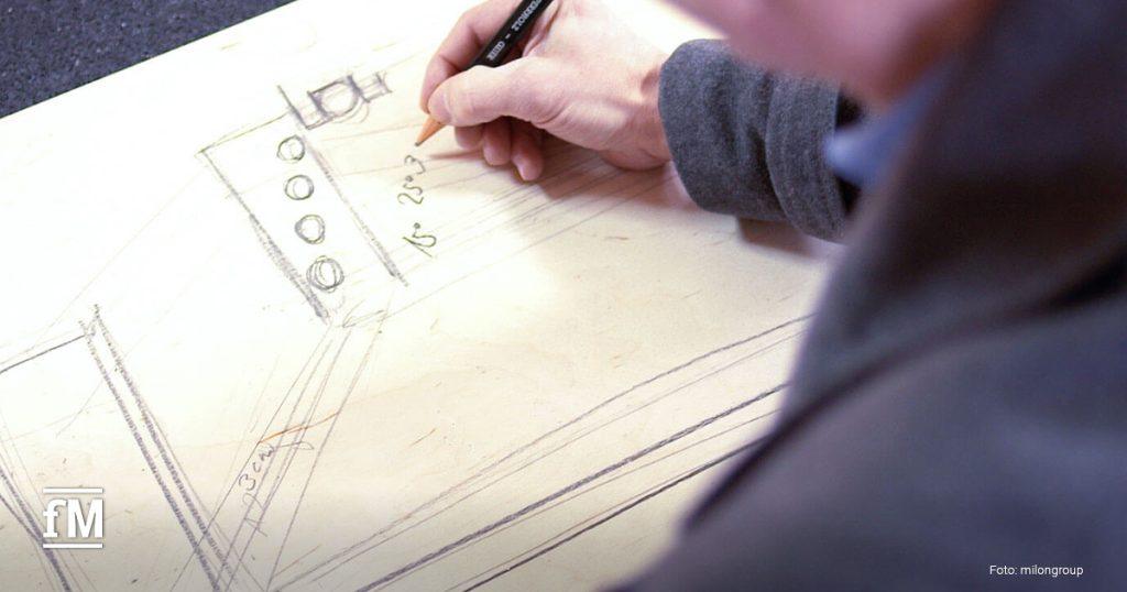 Nahaufnahme einer technischen Skizze auf Holzplatte, Hand zeichnet mit Bleistift Details und Maße.