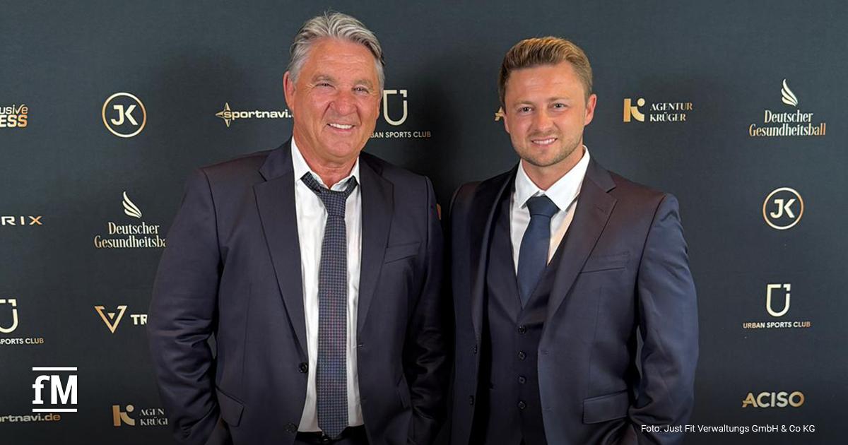 Frank Böhme (links) steht in dunkelblauem Anzug und graukarierter Krawatte vor einer Sponsorenwand des Deutschen Gesundheitsballs, rechts neben ihm steht ein weiterer Mann, ebenfalls im dunkelblauem Anzug und gleichfarbiger Krawatte. Beide Männer tragen weiße Hemden.