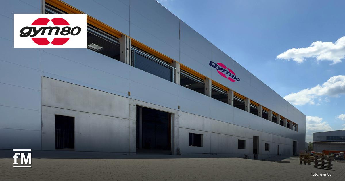 Gebäude mit gym80 Logo in Gelsenkirchen, aufgenommen bei Tageslicht, Produktionshalle mit moderner Fassade und sichtbarer Firmenbeschriftung.