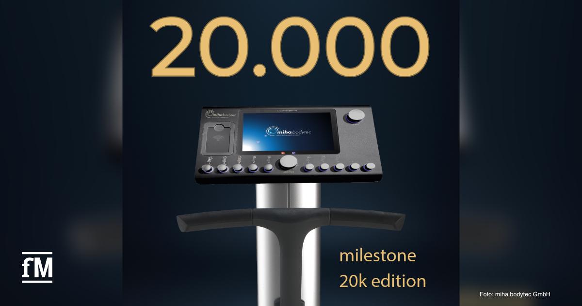 Ein schwarzes EMS-Bediengerät von miha bodytec steht im Mittelpunkt des Bildes vor dunkelblauem Hintergrund. Darüber steht groß die Zahl '20.000'. Unten rechts ist in kleiner Schrift 'milestone 20k edition' zu lesen. In der linken unteren Ecke befindet sich das Logo von fitness MANAGEMENT.