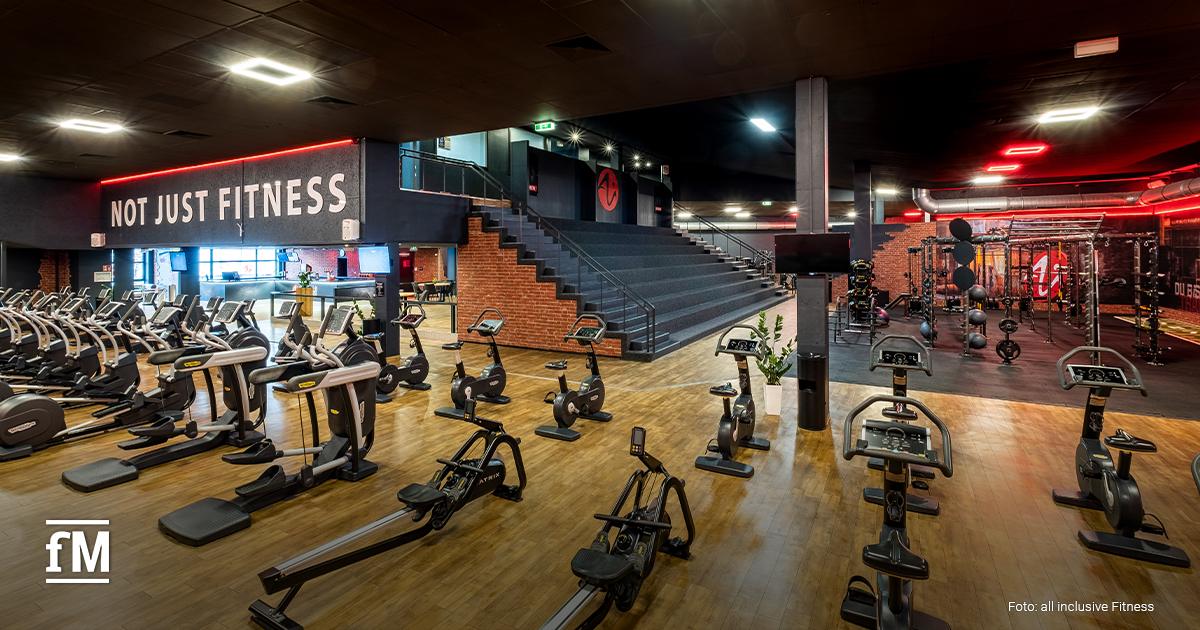 Großer Trainingsbereich mit Cardio-Geräten, Rudergeräten und einem Functional-Bereich, darüber ein Schild mit der Aufschrift „Not Just Fitness“.