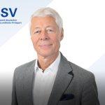 Porträt eines weißhaarigen Mannes (Thomas Wessinghage) in grauem Sakko vor dem Logo des DSSV mit Schriftzug 'Arbeitgeberverband deutscher Fitness- und Gesundheits-Anlagen'.