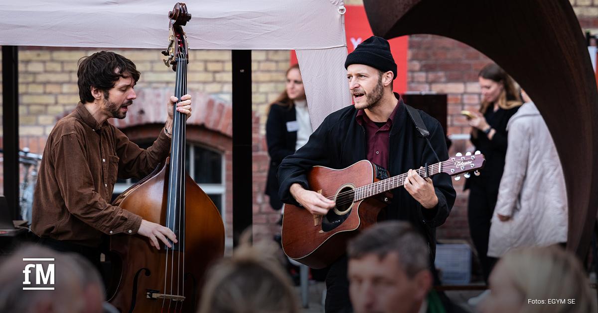 Zwei Musiker spielen Gitarre und Kontrabass beim Health & BBQ im Freien.