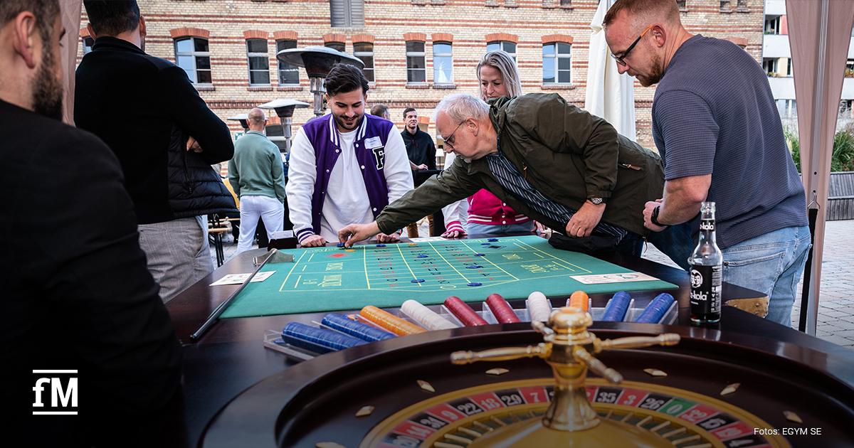 Mehrere Personen spielen an einem Roulette-Tisch im Freien