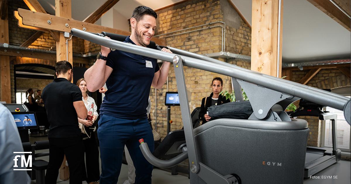 Ein Mann trainiert an einem Fitnessgerät von EGYM in einem Showroom