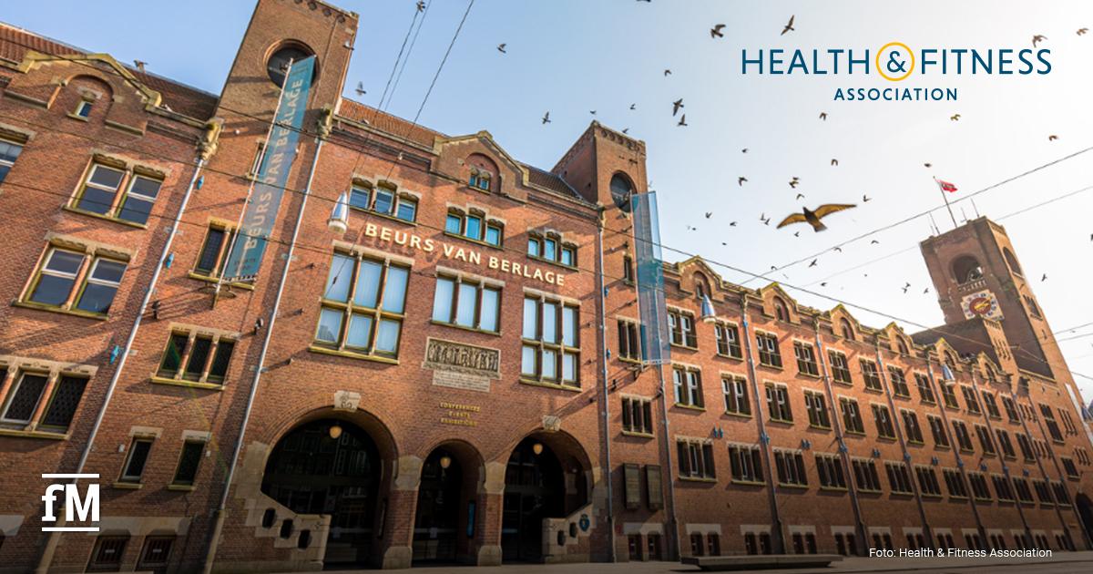 Fassade des Beurs van Berlage in Amsterdam mit Backsteinarchitektur und Schriftzug über dem Eingang. Oben rechts das Logo der Health & Fitness Association.
