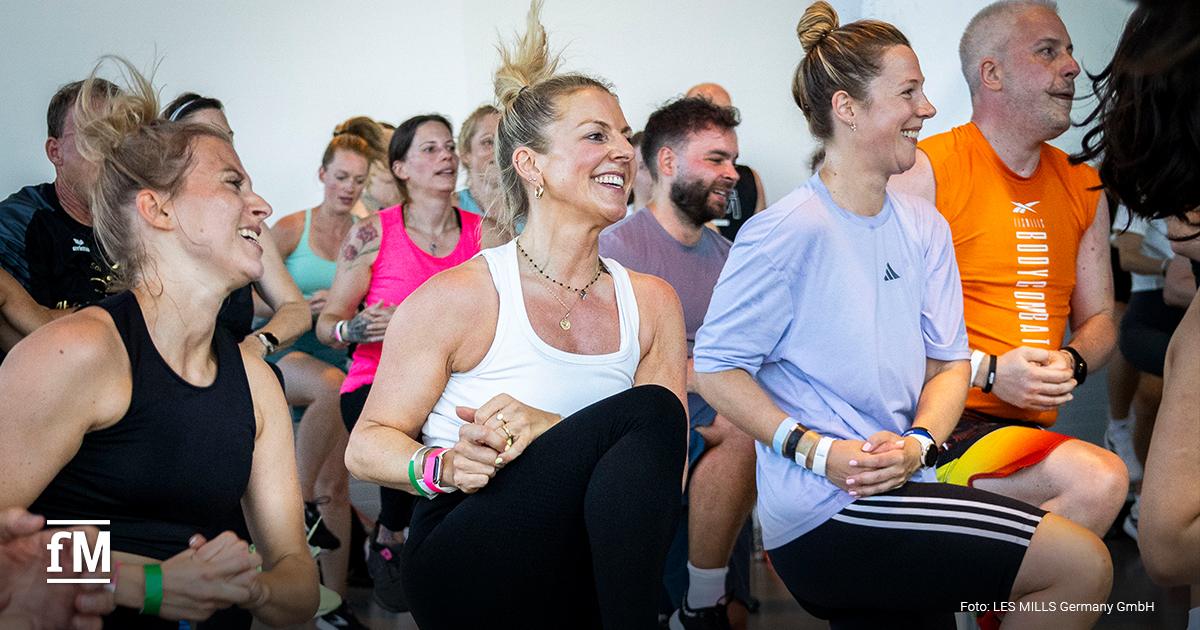 Frau mit Zopf mit Gruppe in seitlicher Yoga-Drehung