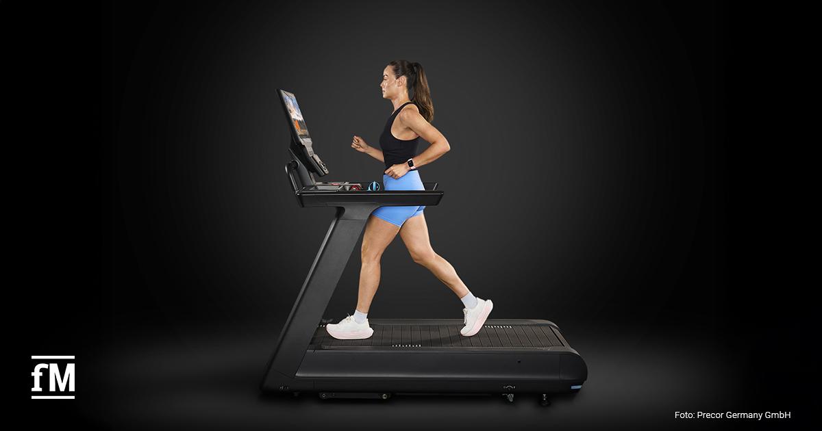 Frau läuft auf einem Precor Breakaway Laufband, seitliche Ansicht mit Konsole.