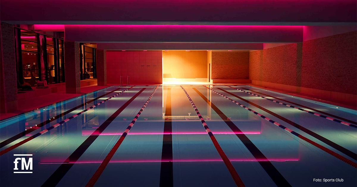 Schwimmbecken mit abgetrennten Bahnen und pinker LED-Beleuchtung.