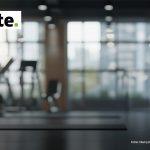 Logo von Deloitte, im Hintergrund ein modernes Fitnessstudio mit Trainingsgeräten; zwei Männer sind mit Namen in separaten Kreisen abgebildet.