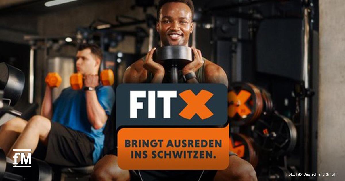 Zwei Personen trainieren in einem Fitnessstudio mit Hanteln, im Vordergrund das FitX-Logo und der Schriftzug 'Bringt Ausreden ins Schwitzen'.