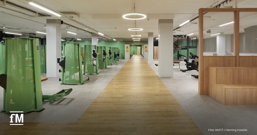Gerätebereich im McFIT Obergiesing mit grünen Trainingsmaschinen und breitem Holzlaufweg