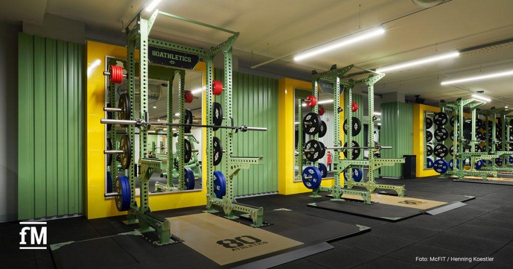 Kraftbereich im McFIT Obergiesing mit grünen Half Racks und farbigen Gewichtsplatten