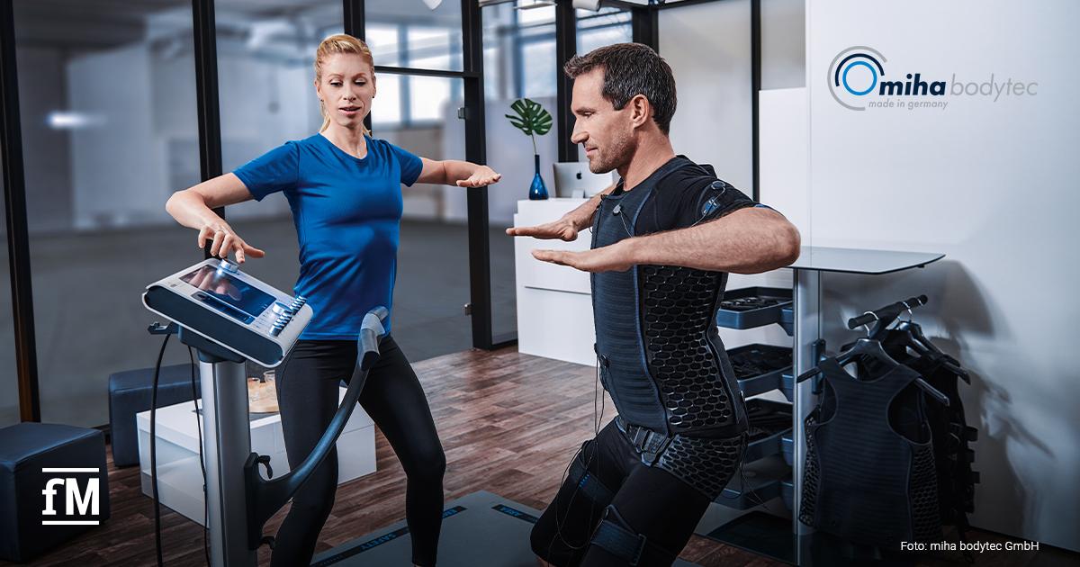 Zwei Personen beim EMS-Training an einem Gerät von miha bodytec in einem modernen Studio.