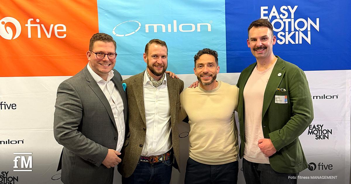 Vier Personen (Bernhard-Stefan Müller, Wolfgang Packi, Wolf Harwath & Janosch Marx) stehen dicht nebeneinander vor einer Wand mit den Logos von five, milon und Easy Motion Skin.