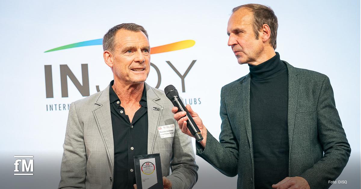 Zwei Männer im Interview, einer hält eine Auszeichnung des Deutschen Fairness-Preises 2025.