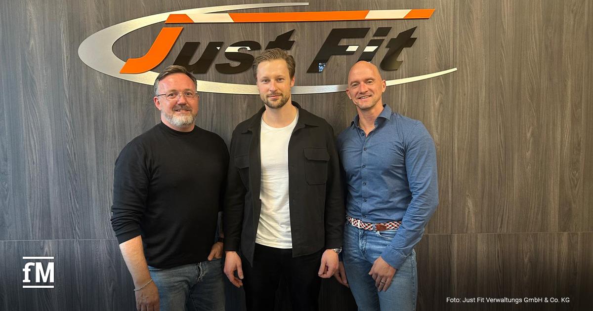 Marc Holthausen, Samuel Zabel und Oliver Neverla stehen vor dem Just Fit Logo.
