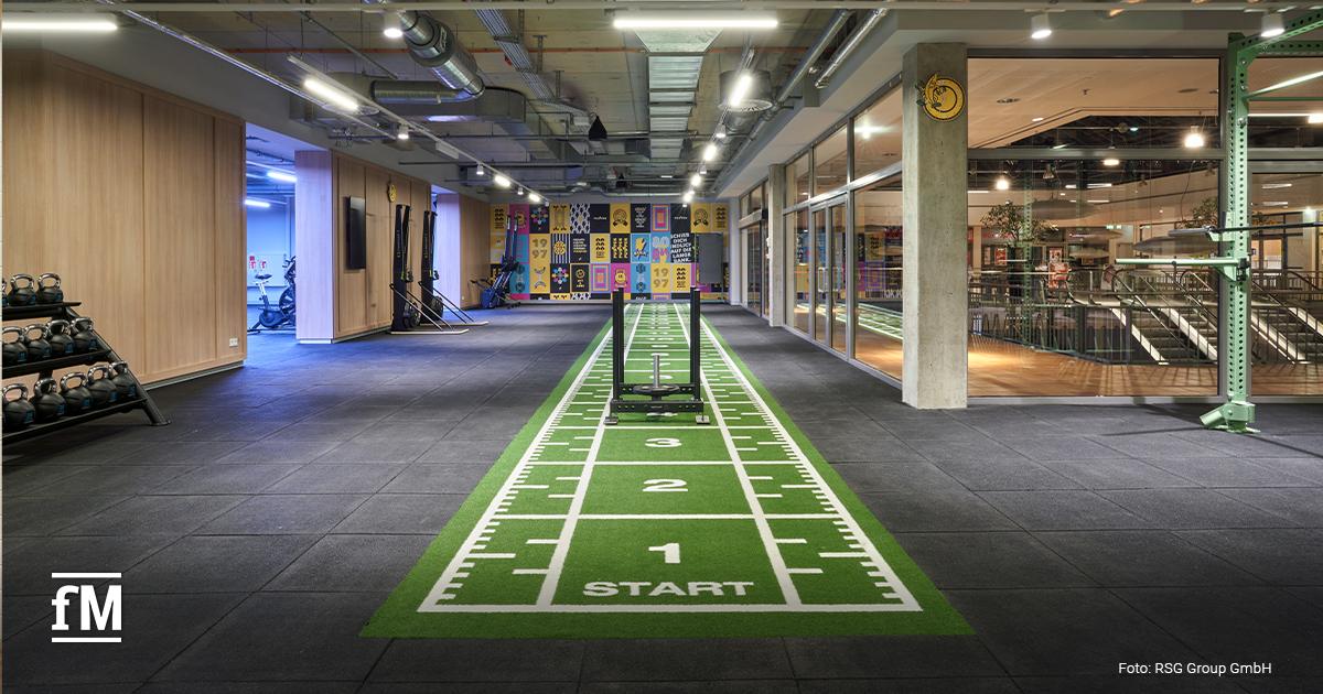 Functional-Zone mit grünem Turf mit Startmarkierungen, Gewichtsschlitten und Kettlebell-Regal im McFIT Berlin-Prenzlauer Berg.