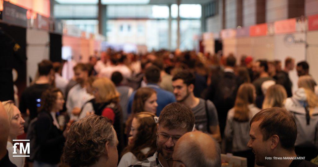 Dicht gefüllte Gänge, zahlreiche Menschen bewegen sich zwischen den Messeständen.