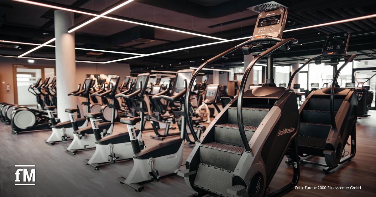 Moderner Cardio-Bereich im Fitnessstudio mit Crosstrainern und StairMaster-Geräten.
