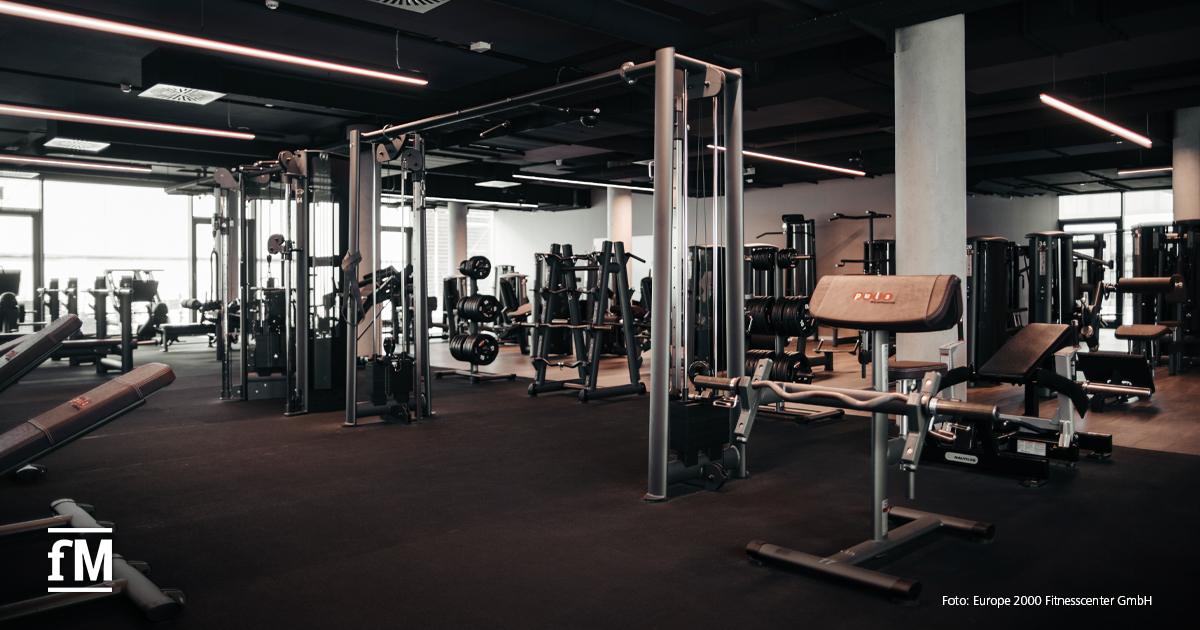 Krafttrainingsbereich mit Maschinen, Freihanteln und Seilzugstationen