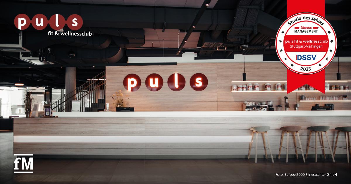 Empfangsbereich des puls fit & wellnessclubs Stuttgart-Vaihingen mit beleuchtetem Logo und moderner Tresenanlage, ausgezeichnet als 'Studio des Jahres 2025'.
