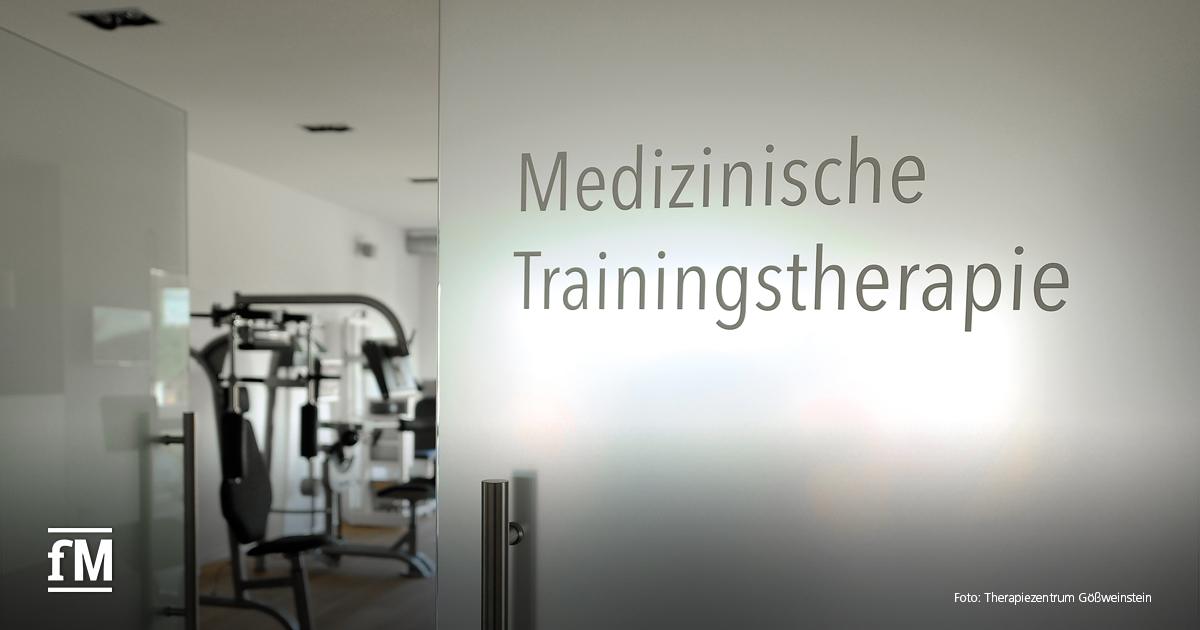 Glastür mit der Aufschrift „Medizinische Trainingstherapie“, dahinter Trainingsgeräte im Raum sichtbar.