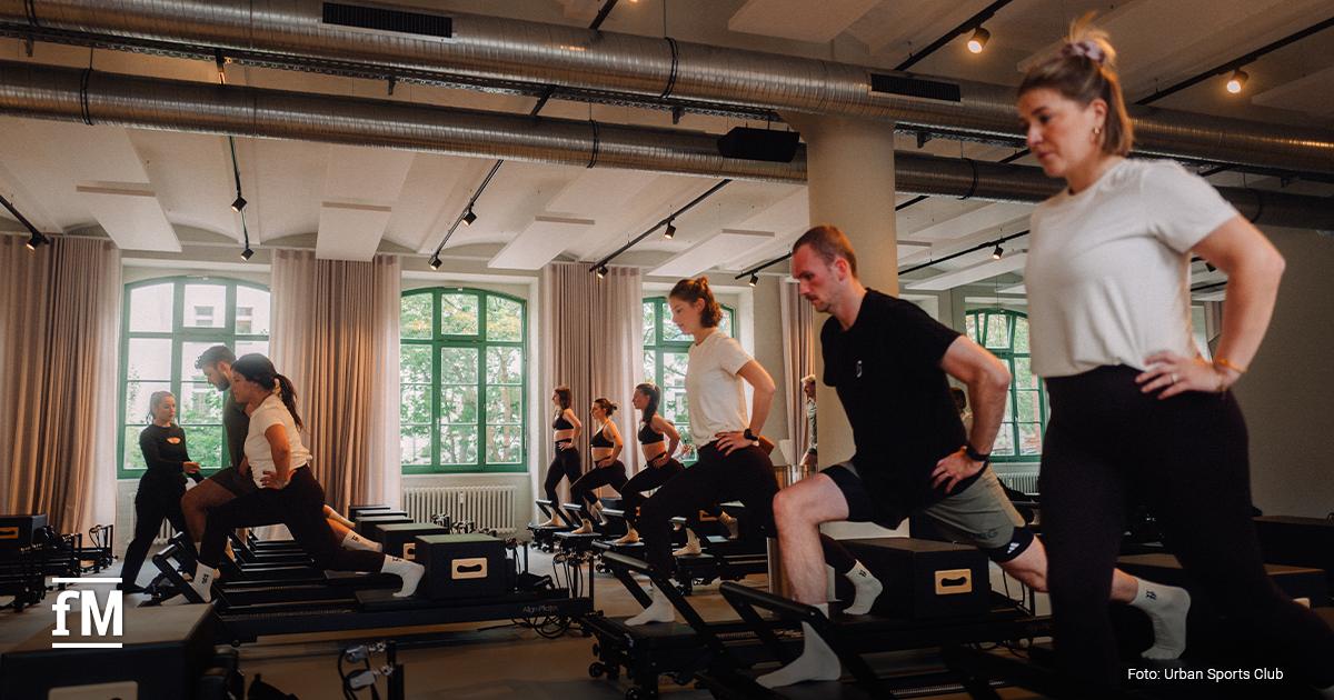 Gruppe von Personen trainiert an Reformer-Geräten in einem hellen YTTP-Studio