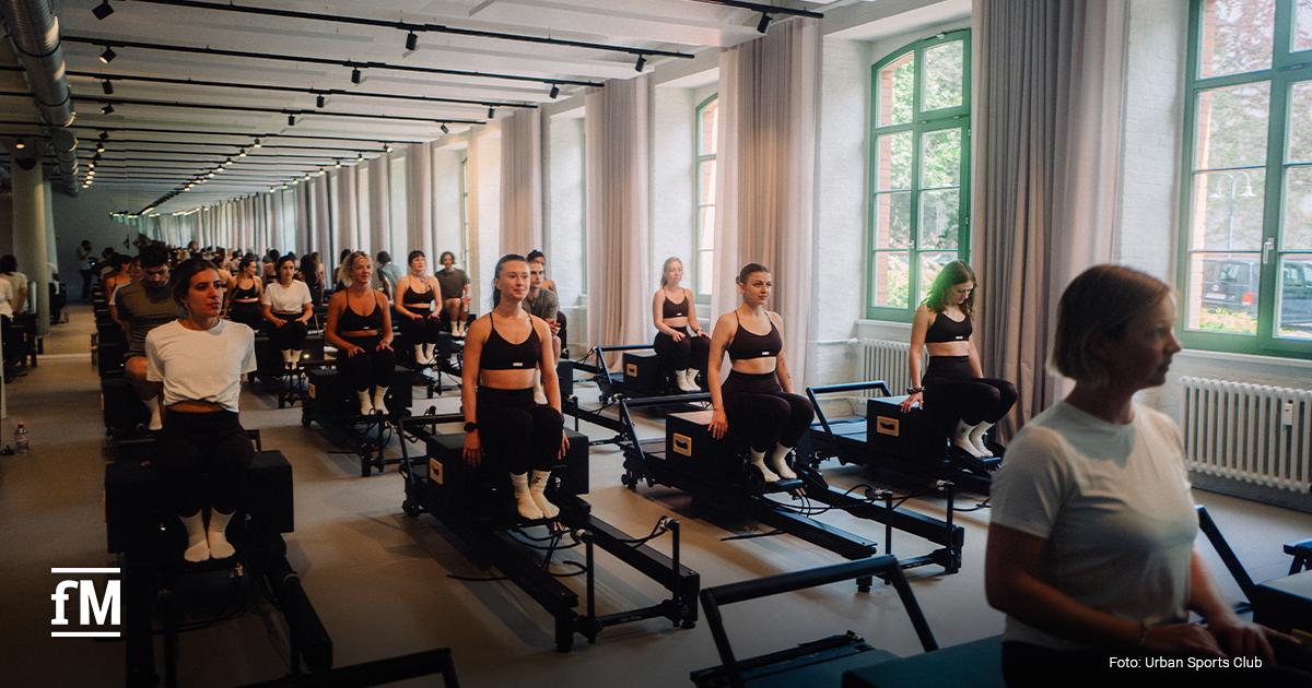 Trainierende in einem modernen YTTP-Studio auf Reformer-Geräten bei einer Gruppenstunde