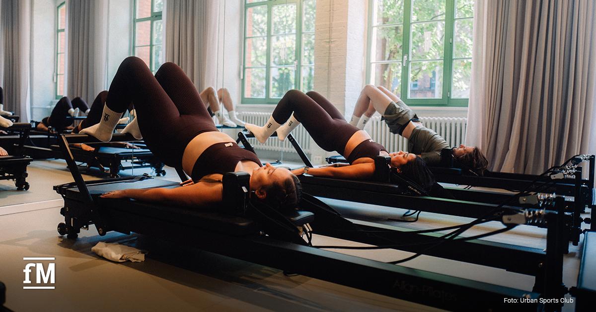 Gruppe von Personen trainiert an Reformer-Geräten in einem hellen YTTP-Studio