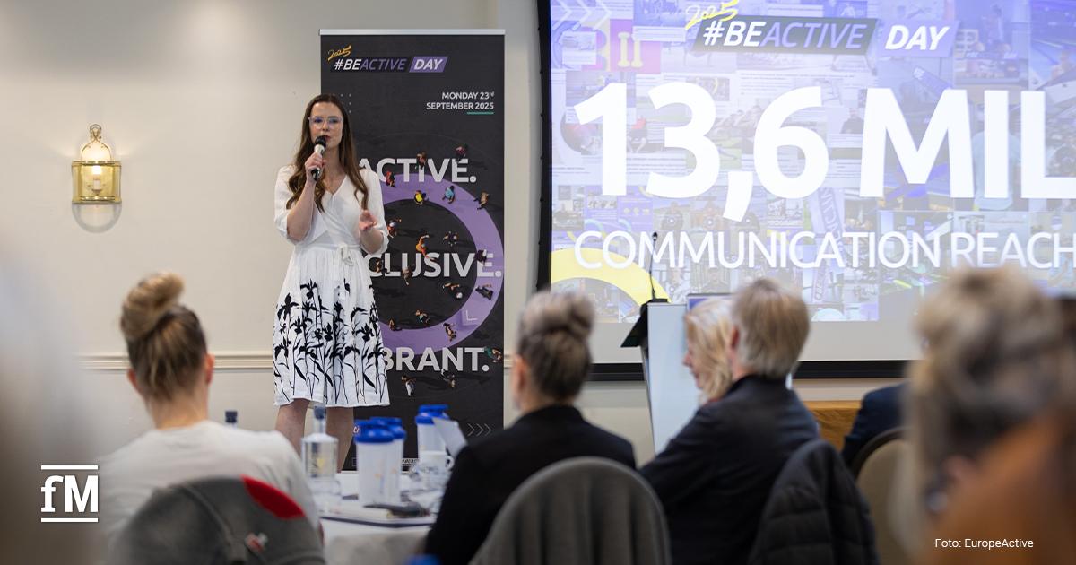 Konferenzteilnehmende sitzen im Plenum und hören einem Vortrag zu.