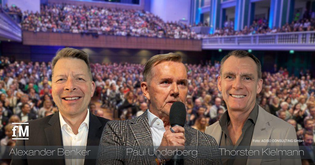 Drei Branchenvertreter – Alexander Benker, Paul Underberg und Thorsten Kielmann – vor einer großen, vollbesetzten Kongresshalle.