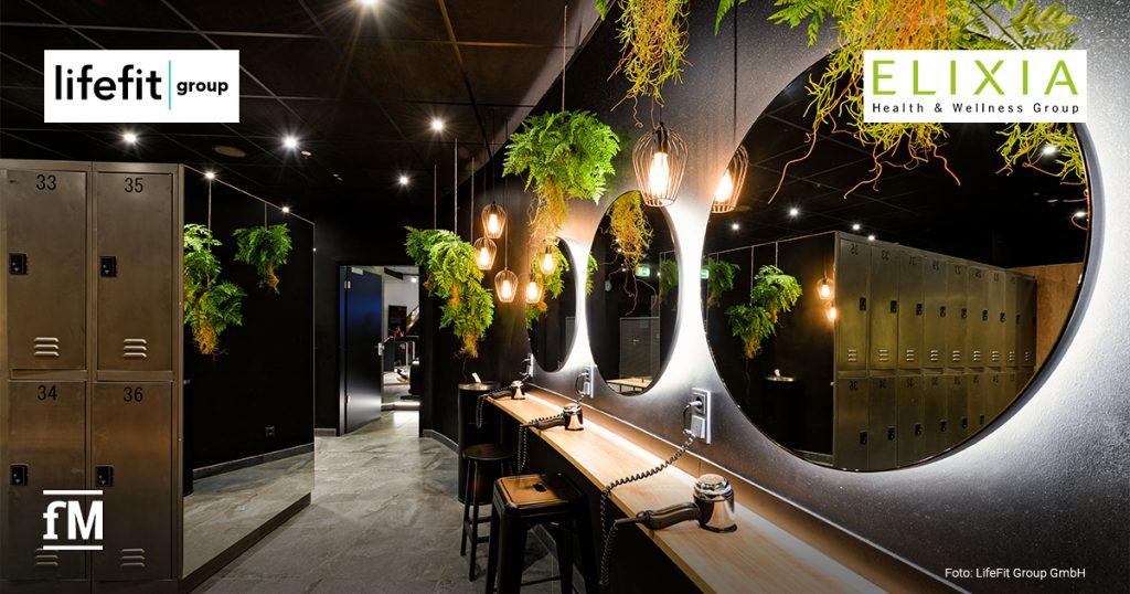 Moderner Umkleide- und Stylingbereich mit runden Spiegeln, Hängepflanzen und Schließfächern in einem Fitness First BLACK (Berlin Steglitz) der LifeFit Group