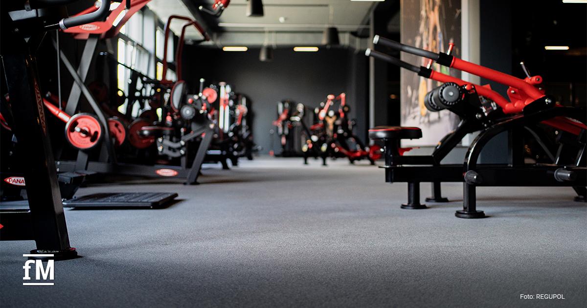 Trainingsgeräte in einem Fitnessraum auf grauem Bodenbelag.