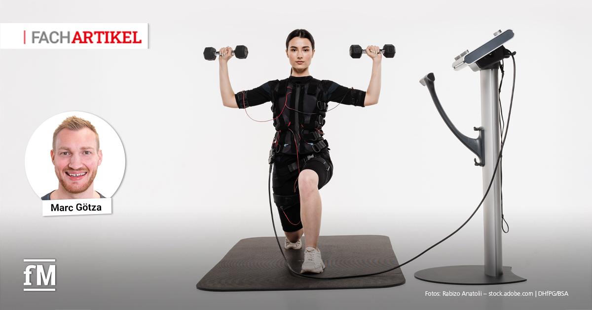 Simultanes EMS- und Freihanteltraining Im Vordergrund kniet eine Frau im Ausfallschritt auf einer schwarzen Trainingsmatte und hält in beiden Händen Kurzhanteln auf Schulterhöhe. Sie trägt einen schwarzen EMS-Anzug mit Elektroden und Kabeln, die rechts im Bild zu einem aufrecht stehenden EMS-Gerät mit Display und Standfuß führen. Links oben ist ein Portrait von Marc Götza eingeblendet.